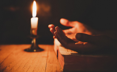 praying hands and candle